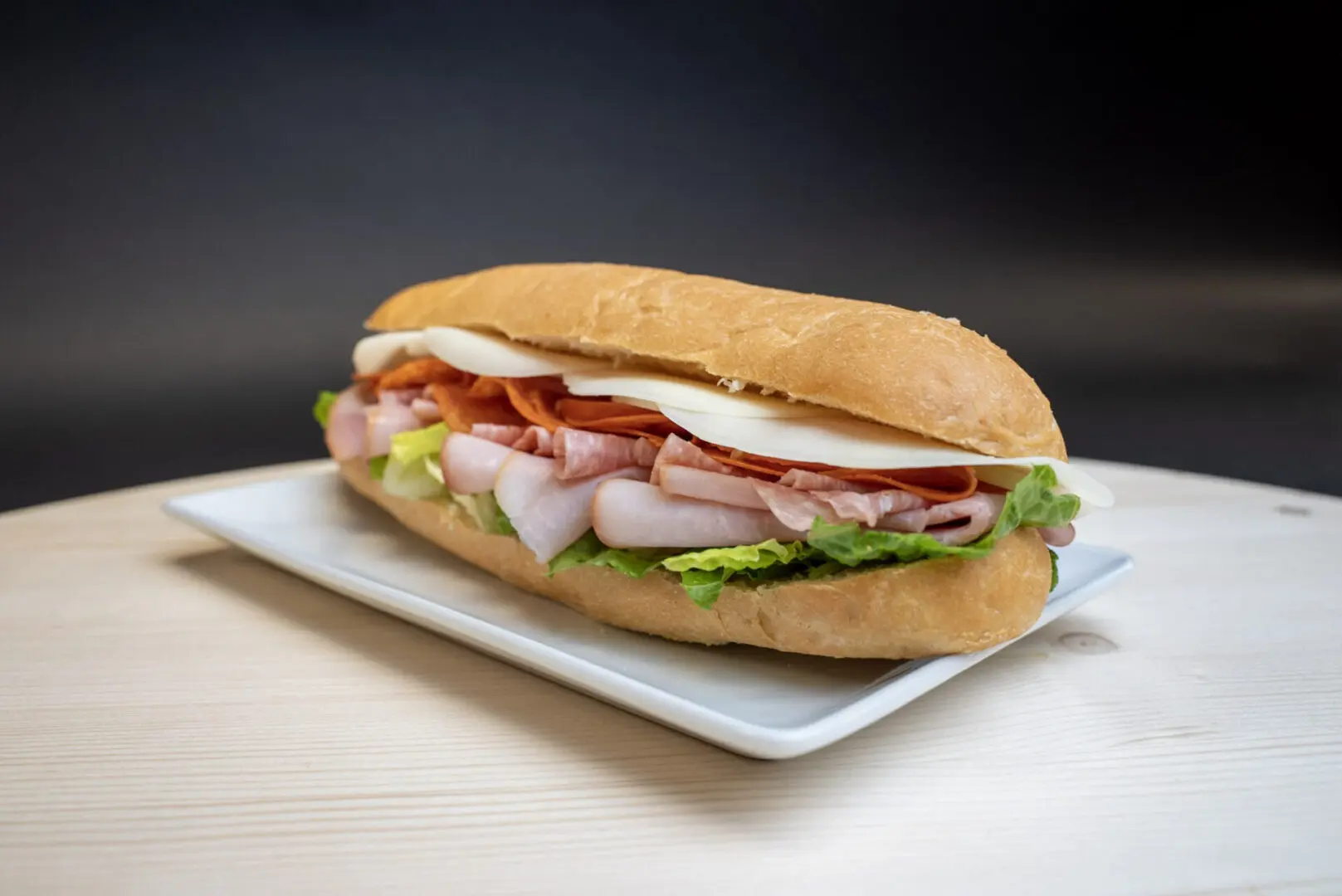 A sandwich on a plate sitting on top of a table.